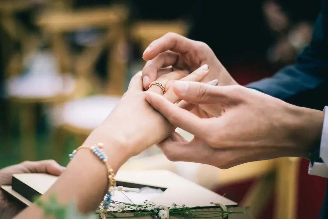 Bridal couple holding hands, showing wedding rings stock photo